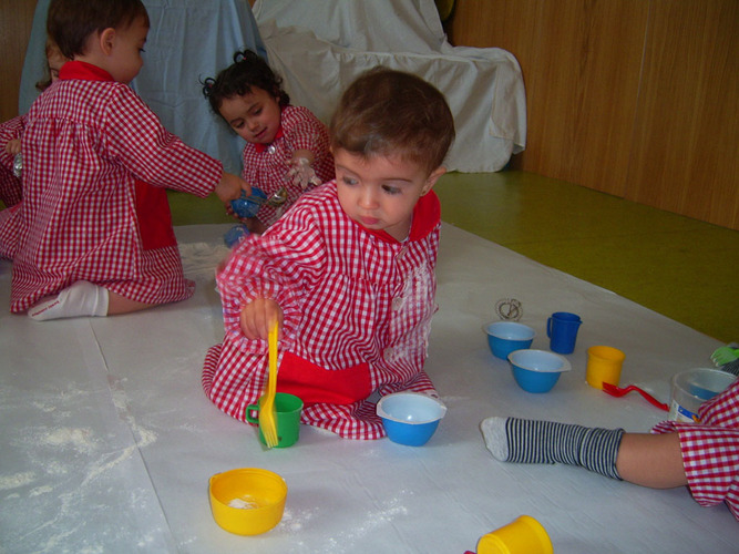 Niños pequeños jugando con cacharritos.