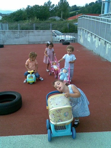 Niños y niñas jugando con los carricoches.