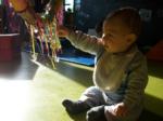 Niño tacando tiras de colores bajo la luz