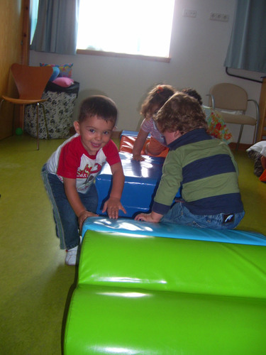Niños jugando enter colchonetas.