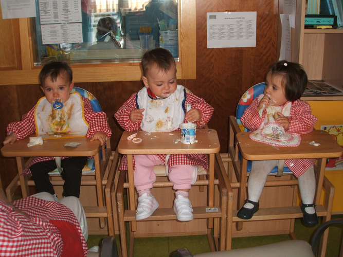 Tres bebés comiendo en las tronas.