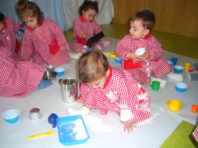 Grupo de niños jugando con cacharritos y harina.