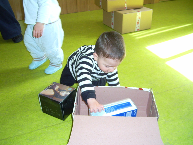Niño pequeño jugando con unas cajas de cartón.