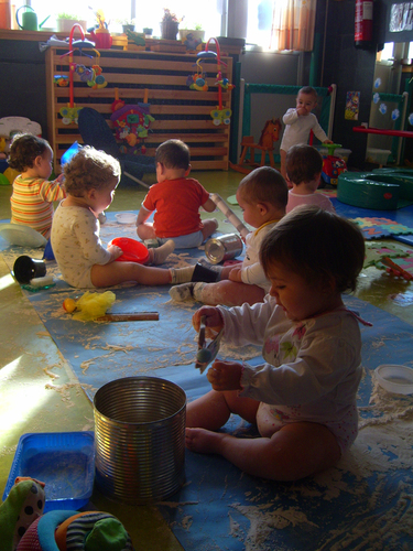Grupo de niños muy pequeños jugando con harina.