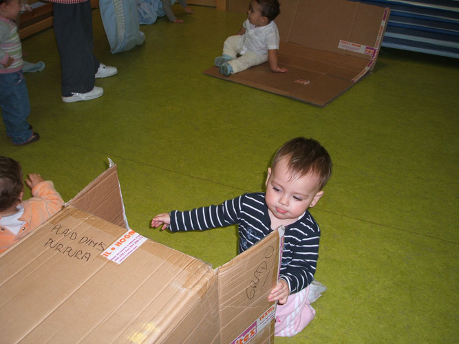 Niños jugando con cajas de cartón.