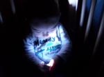 Un niño a oscuras alumbrandose con una linterna
