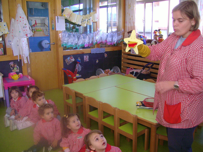 Profesoras contando un cuento a unos niños.