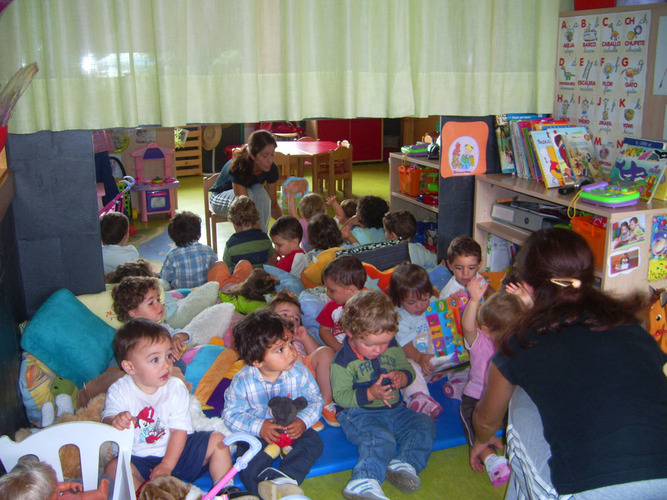 Profesora dando explicaciones a un grupo de niños.