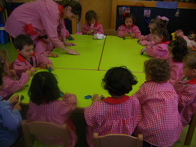 Profesora con sus alumnos jugando con plastilina.