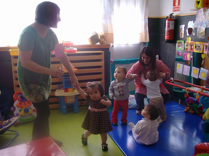 Profesoras contando un cuento a niños muy pequeños.