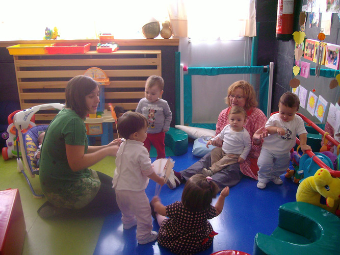 Profesoras contando un cuento a niños muy pequeños.
