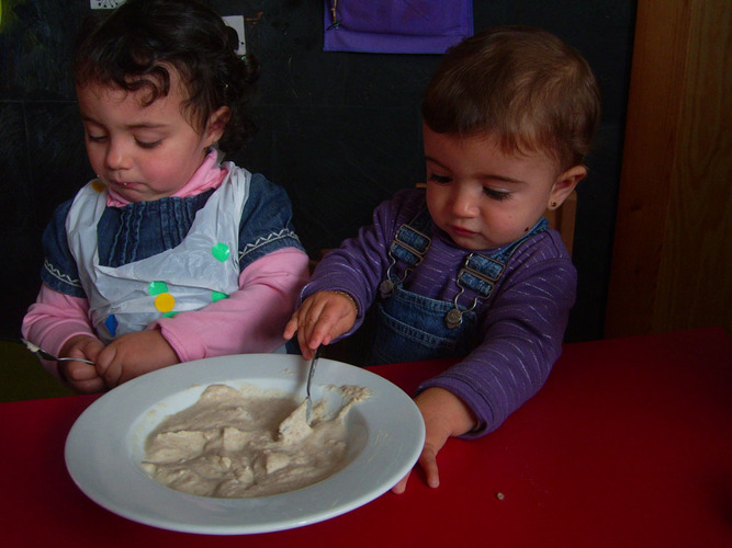 Niñas comiendo una papilla.