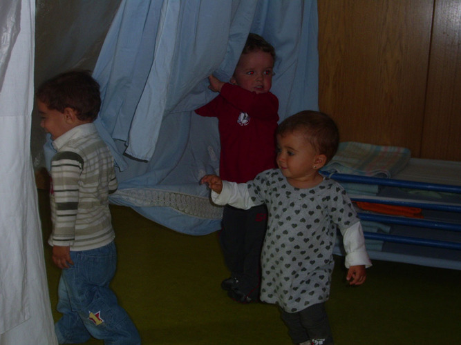 Niños jugando con unas telas.