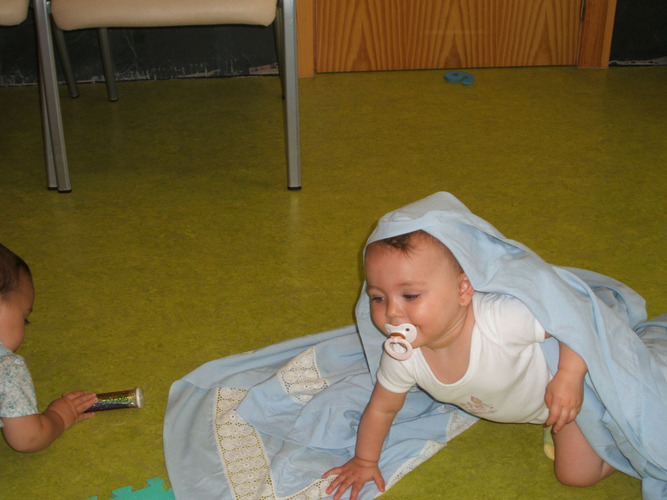 Niño debajo de una sábana.