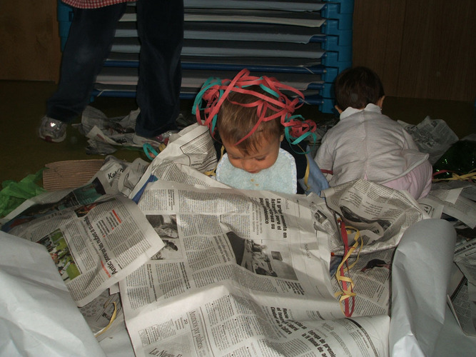 Niño envuelto enter hojas de periodico.