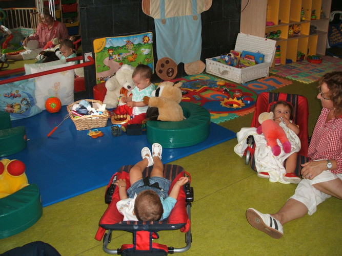 Niños echados en unas hamacas junto a su profesora.