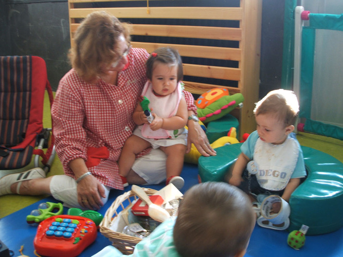 Profesora con niños muy pequeños jugando.