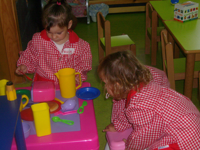 Niñas jugando a las cocinitas.