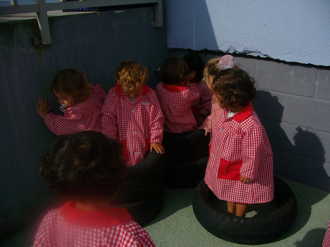 Niños jugando con ruedas de coche.