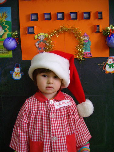 Niña posando con un gorro de Papa Noel.