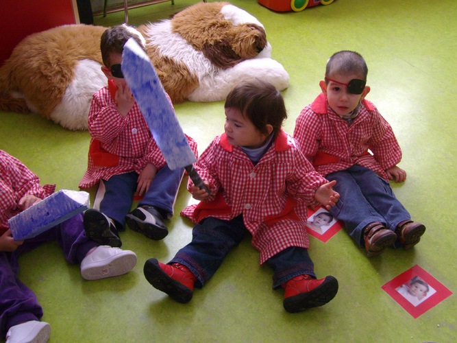 Dos niños con un parche de pirata en los ojos, y una niña sujetando una espada.