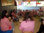 Niños y educadores en corro cantando Villancicos