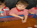 Un niño sacando agua con colorante naranja