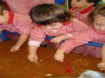 Varios niños metiendo las manos en un tanque con colorante naranja