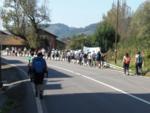 Peregrinos en marcha por una carretera asfaltada