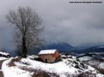 Viene la tormenta, paisaje de cabaña en el monte con entorno nevado