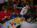 Varios padres con un niño preparando adornos