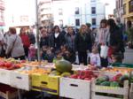 Madres y niños en un puesto de frutas