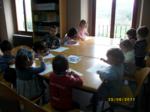 Niños en una gran mesa trabajando con libros