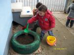 Un niño rellenando un neumático usado con tierra