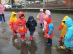 Varios niños pisando charcos con botas de agua