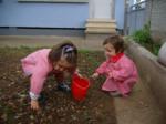 Dos niñas recogiendo frutos secos del patio de la escuela