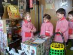 Variso niños simulando la compra en una tienda de alimentos 
