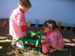 Dos niños jugando con tierra en un huerto dentro del colegio