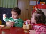 Dos niños comiendo en tazones de madera