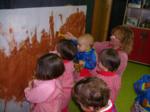 Niños pintando con barro, directamente con sus manos