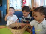 Tres niños jugando con frutos secos de una cesta