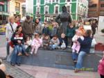 Todos juntos padres y niños posando junto a la estatua de la vendedora del mercado de Grao