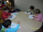Niños en una mesa redonda coloreando libros