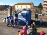 Una educadora reciclando cartón ante la mirada de los niños